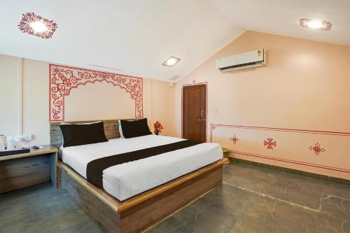 Un pat sau paturi într-o cameră la Collection O Raghunathpura Uptown Chittorgarh Formerly Padmavati Resort
