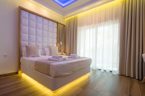 a bedroom with a large bed and a large window at Porto Marine Hotel in Platamonas