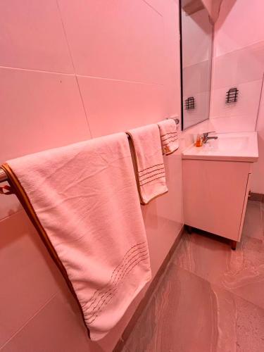 a pink bathroom with a sink and a towel at Bright & Quiet 1BR with Courtyard in Williams Landing