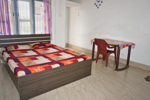 a bedroom with a bed and a table and a chair at Entire 1BHK & 2BHK private apartments with personal kitchen, 767ooo54oo, TAJ RESIDENCY Holiday Homestay in Jorhat