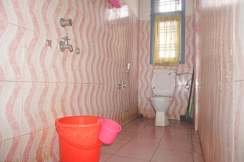 a bathroom with a toilet and a bucket at Entire 1BHK & 2BHK private apartments with personal kitchen, 767ooo54oo, TAJ RESIDENCY Holiday Homestay in Jorhat