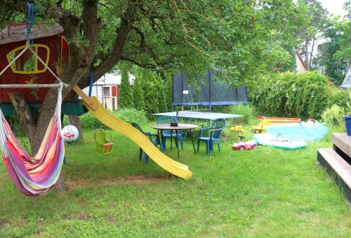 a playground with a slide and a table in a yard at Berlinurlaub im Grünen, Pool-Whirlpool beheizt, Sauna, Spielplatz, Grill, 3 Doppelzimmer in Blankenfelde