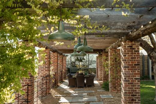 a brick patio with two green hanging lights at Vale Hill House in Lawrence