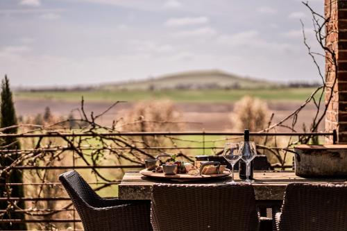 a table with a plate of food and wine glasses at Vale Hill House in Lawrence