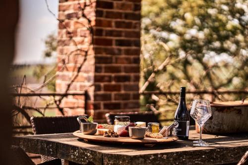a table with a plate of food and a bottle of wine at Vale Hill House in Lawrence