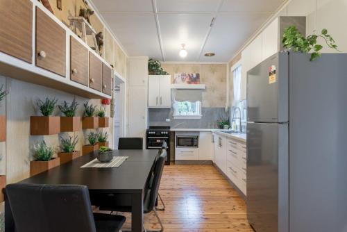 a kitchen with a table and a refrigerator at Boutique Double Room in Carramar - Close to Station & Shops - Shared Bathroom in Villawood
