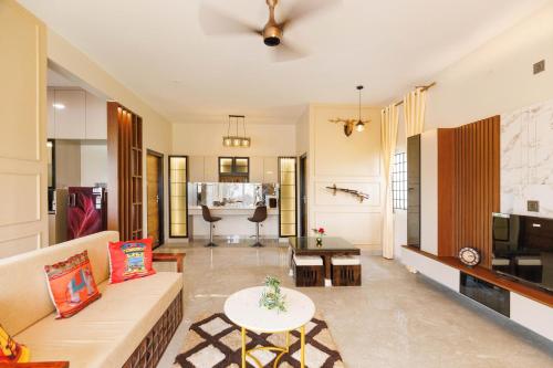a living room with a couch and a table at The Green Haven by StayJade2BHKACPoolLawn in Berikai