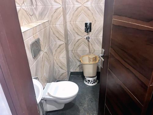 a bathroom with a toilet and a trash can at Hotel the haveliya-1 mint from new delhi railway station & connaught place in New Delhi