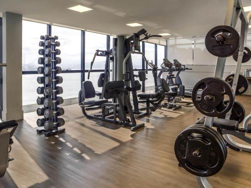 a gym with several treadmills and weights at Novotel Florianopolis in Florianópolis