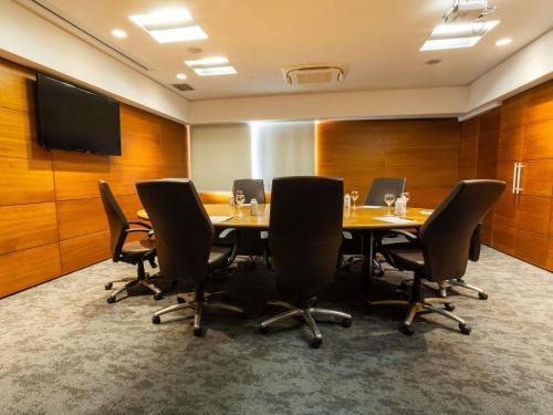 a conference room with a long table and chairs at Novotel Florianopolis in Florianópolis
