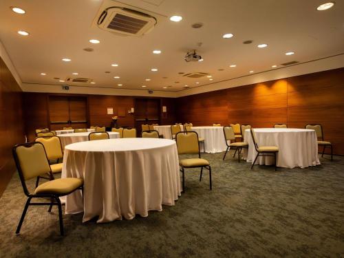 a conference room with white tables and chairs at Novotel Florianopolis in Florianópolis