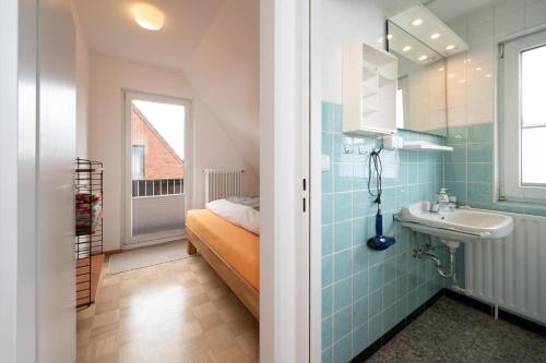 a bathroom with a sink and a bed in a room at Kleine Koje Heide in Heide