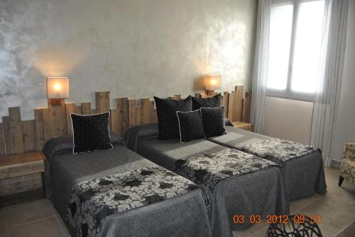 a bedroom with two beds and two lamps on the wall at Santa Bárbara in Sant Corneli de Cercs 