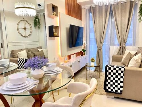 a living room with a glass table and chairs at Luxe Living in Iloilo City