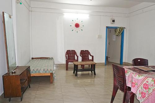a living room with chairs and a table and a clock on the wall at Entire 1BHK & 2BHK private apartments with personal kitchen, 767ooo54oo, TAJ RESIDENCY Holiday Homestay in Jorhat