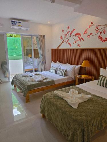 a hotel room with two beds and a window at Kyle's Bed and Breakfast DMall Boracay in Boracay