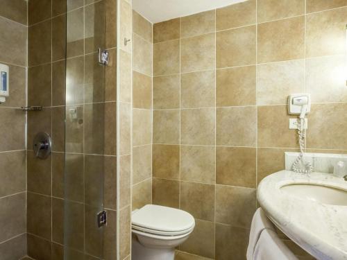 a bathroom with a toilet and a sink at Ibis Mexico Perinorte in Mexico City