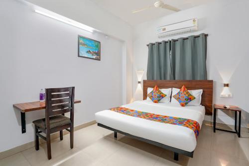 Un dormitorio con una cama, un escritorio y una silla. en FabExpress Dream Nest, en Hyderabad