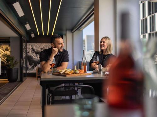 two people sitting at a table in a restaurant at Ibis Christchurch in Christchurch