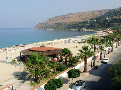 a beach with palm trees and a bunch of people at Hotel Ristorante Antica Marina in Nicotera Marina