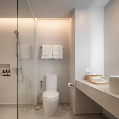 ein weißes Badezimmer mit Toilette und Dusche in der Unterkunft Terra Nara in Pattaya