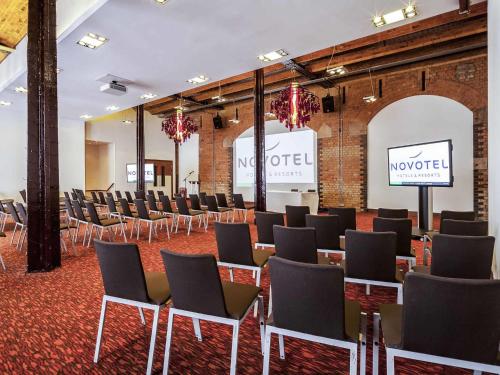 a room with rows of chairs and a stage at Novotel Cardiff Centre in Cardiff