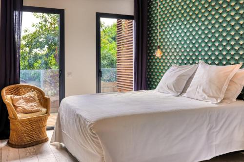 a bedroom with a white bed and a large window at Le Moma by the ocean in Trois Bassins