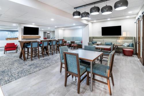 a waiting room with tables and chairs and a piano at Hampton Inn Sheridan in Sheridan