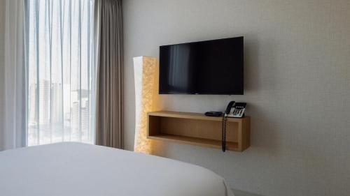 a hotel room with a television and a phone at Centum Mark Kimstay Yangyang in Yangyang