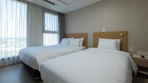 a hotel room with two beds and a window at Centum Mark Kimstay Yangyang in Yangyang