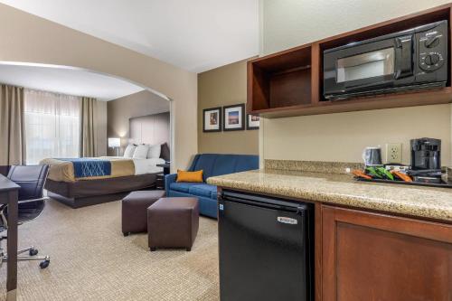 a hotel room with a kitchen and a bedroom at Comfort Inn & Suites North Little Rock McCain Mall in North Little Rock