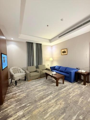 a living room with a blue couch and a table at فندق الفرسان المتحدة شارع حراء - "سانسا" in Jeddah