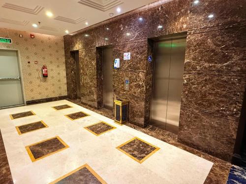 a lobby with an elevator with ailed floor and doors at فندق الفرسان المتحدة شارع حراء - "سانسا" in Jeddah