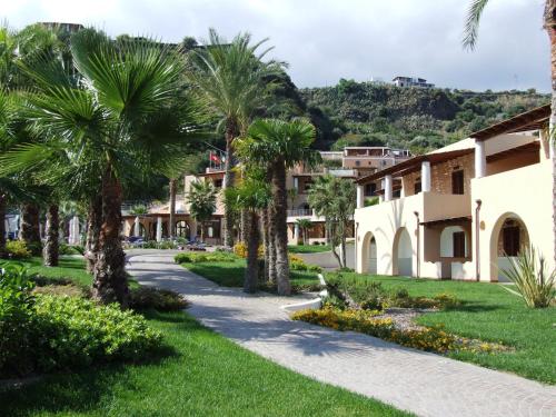 a path through a resort with palm trees at Hotel Aktea in Lipari
