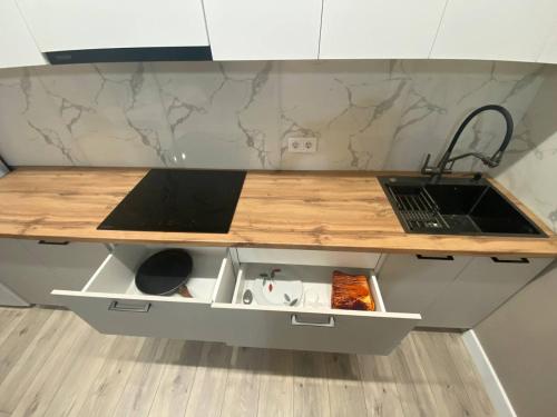 a kitchen counter with a sink and a laptop on it at Brick house in Astana