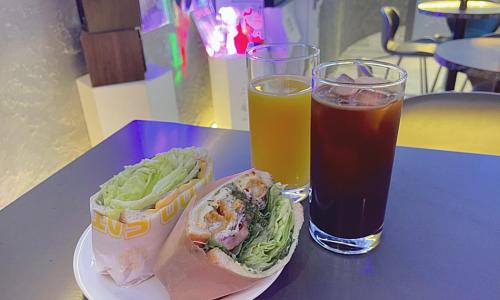 a plate with a sandwich and a drink on a table at Jamsil Orosie Tourist Hotel in Seoul