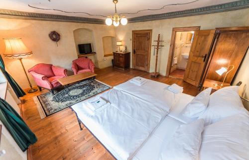 a living room with a bed and two chairs at Alt Straninger in Český Krumlov