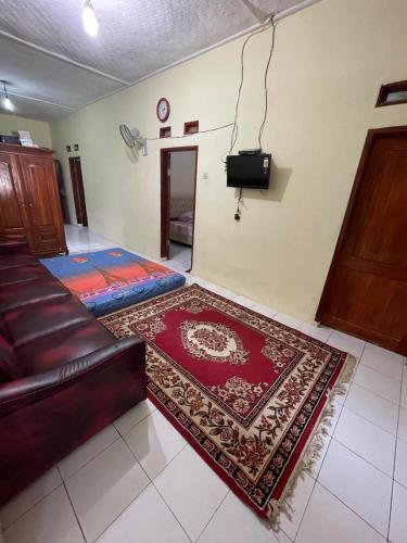 a living room with a couch and a rug at Homestay Pelangi in Pangandaran