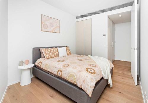 a bedroom with a bed and a white wall at The Marina Outlook - Elevated Views in Shellharbour