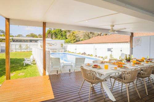 a patio with a table and chairs and a pool at Shoal Shack 72, 72 Tomaree Rd - Pool, Pet Friendly, Wi-Fi, Air Con, Linen in Shoal Bay