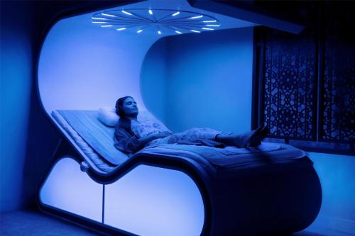 a person laying on a bed in a room at Hilton Salwa Beach Resort and Villas in Abū Samrah