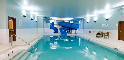 a swimming pool with a slide in the middle of it at Radisson Hotel & Conference Centre Calgary Airport in Calgary
