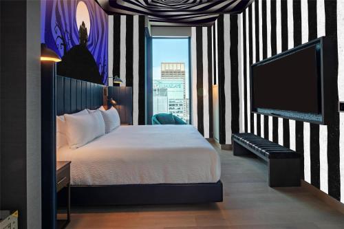 a hotel room with a bed and a flat screen tv at Tempo By Hilton New York Times Square in New York