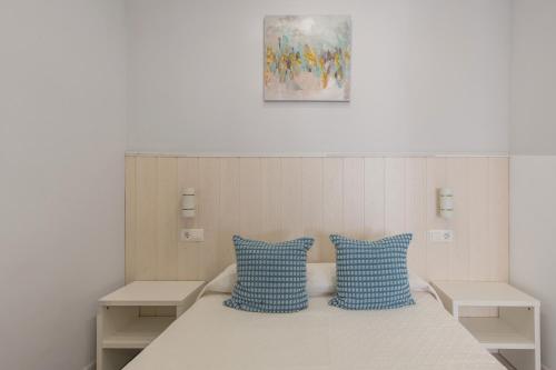 a room with a bed with two blue pillows at Modern Loft in Málaga in Málaga