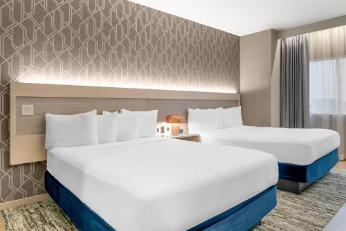 a hotel room with two beds and a window at Radisson Plaza Hotel at Kalamazoo Center in Kalamazoo