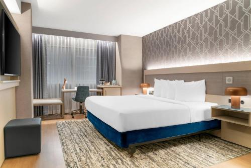 a hotel room with a large bed and a desk at Radisson Plaza Hotel at Kalamazoo Center in Kalamazoo