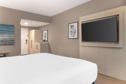 a bedroom with a bed and a flat screen tv at Radisson Plaza Hotel at Kalamazoo Center in Kalamazoo