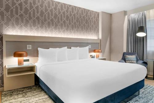 a hotel room with a large bed and a chair at Radisson Plaza Hotel at Kalamazoo Center in Kalamazoo