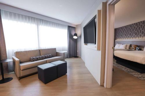 a hotel room with a bed and a couch at Radisson Plaza Hotel at Kalamazoo Center in Kalamazoo