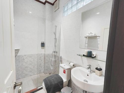 a bathroom with a toilet and a sink and a shower at Luang Prabang Museum Inn & Travel in Luang Prabang